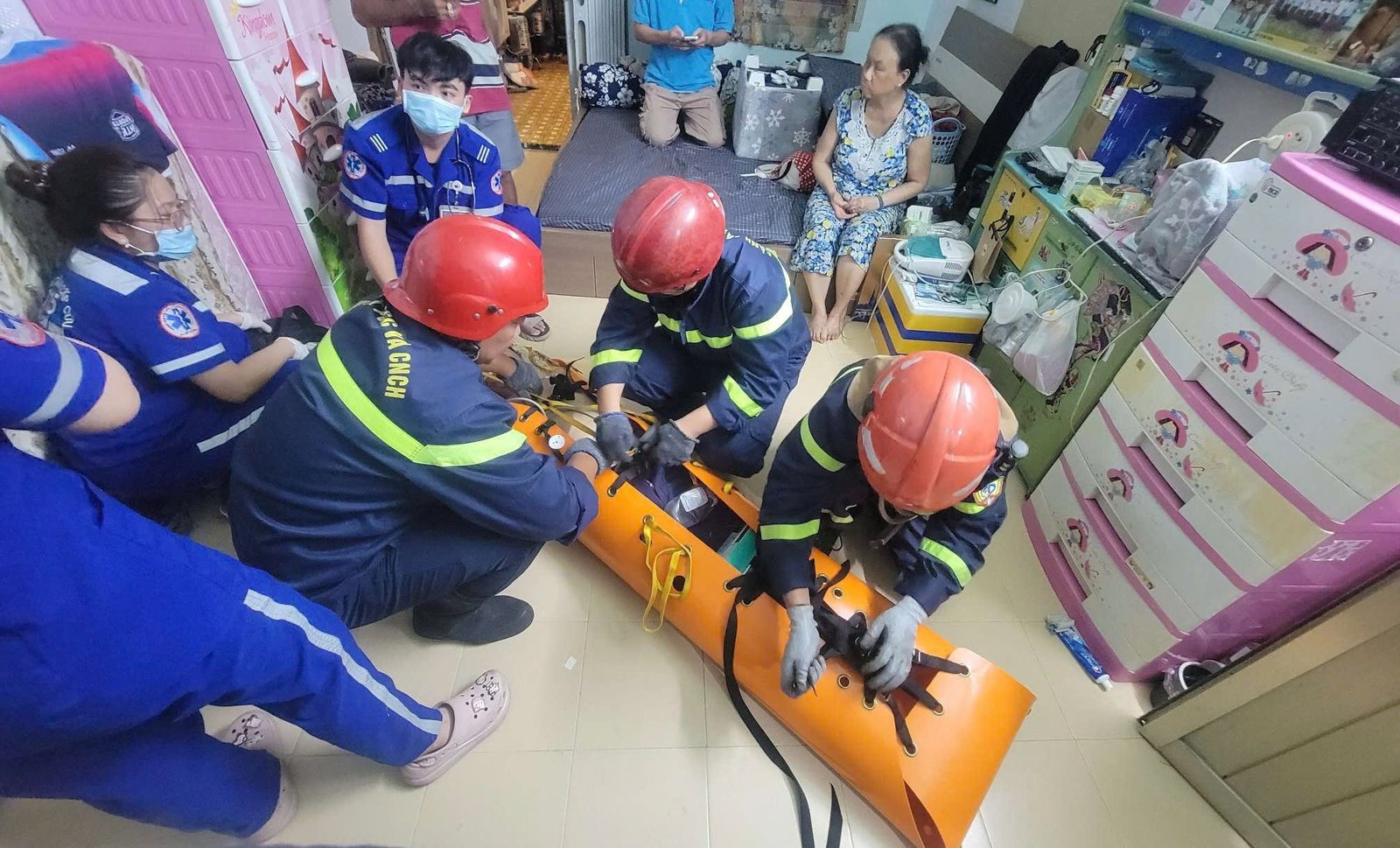 Cảnh sát phòng cháy chữa cháy dùng cáng chuyên dụng cuốn người bệnh lại để đưa x