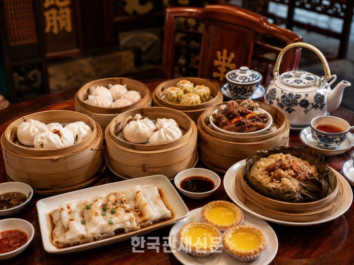 광둥요리의 대표 음식인 딤섬. 새우딤섬과 샤오마이, 차슈바오, 창펀, 에그타르트 등이 전통 광둥식 식탁 위에 차려져 있다. | 기사의 이해를 돕기위해 AI로 생성한 이미지 입니다